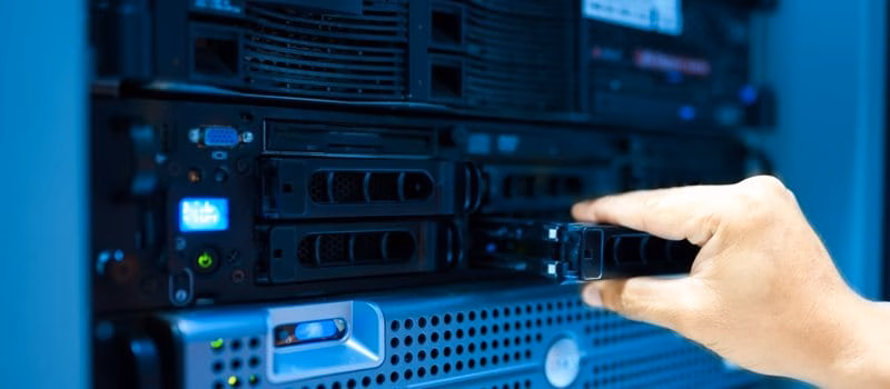 IT engineer repairing a server in a datacenter Hand eines IT-Technikers, der eine Festplatte in einen Server im Rechenzentrum einsetzt oder herausnimmt.